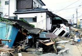 崩れた民家やひっくり返った車両が残る５日朝の熊本県人吉市内（神戸国際支縁機構提供）