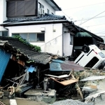 崩れた民家やひっくり返った車両が残る５日朝の熊本県人吉市内（神戸国際支縁機構提供）