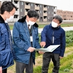 兵庫県内初の「防災協力農地」に登録した畑で、伊丹市職員と打ち合わせをする阪部英夫さん（右端）＝伊丹市内