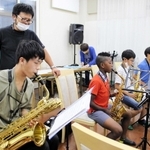 サックスを練習するメンバーと、後ろから指導する高橋知道さん（左から２人目）＝神戸市中央区