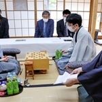 立会人の木村一基九段（右）から封じ手を示される藤井聡太王位（左）。右から２人目は豊島将之九段＝２５日午前、徳島市、渭水苑