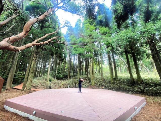 涼しくなった六甲山上。木立に囲まれたステージに立つマウロ・イウラートさん＝神戸市灘区六甲山町