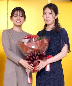 就位式で囲碁の藤沢里菜女流本因坊（左）から花束を贈られる里見香奈女流王位＝東京都千代田区