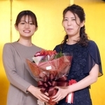 就位式で囲碁の藤沢里菜女流本因坊（左）から花束を贈られる里見香奈女流王位＝東京都千代田区