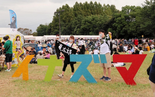 「イナズマ」のモニュメントで記念撮影する来場者ら＝滋賀県草津市