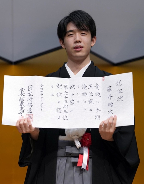 第６３期王位の就位状を手にする藤井聡太王位＝２５日午後、東京都内