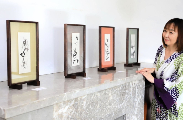 甲骨文字を題材にした作品と和田彩さん＝旧木下家住宅