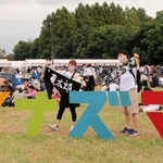 「イナズマ」のモニュメントで記念撮影する来場者ら＝滋賀県草津市