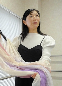 衣装を手に創作の意図を語る向井華奈子さん＝神戸市東灘区住吉本町１