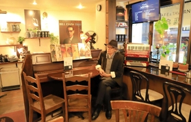 震災後、２度の引っ越しを経て築いた店内でたたずむ小西武志さん＝神戸市中央区北長狭通３、「ＭＯＫＵＢＡ’Ｓ　ＴＡＶＥＲＮ」