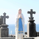 海辺に立つマリア像や十字の墓標がある渕ノ元カトリック墓碑群地＝長崎県五島市