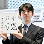 竜王を防衛し、千思万考と揮毫した色紙を示す藤井聡太五冠＝４日午前、鹿児島県指宿市