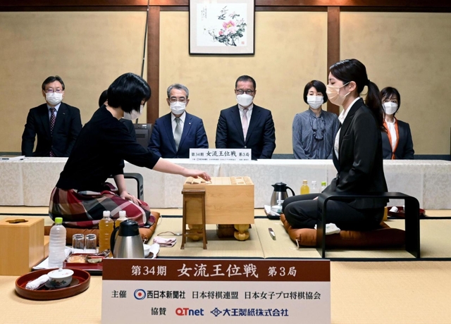 女流王位戦第３局で初手を指す伊藤沙恵女流四段（左）。右は里見香奈女流王位＝２５日午前、福岡県飯塚市、麻生大浦荘