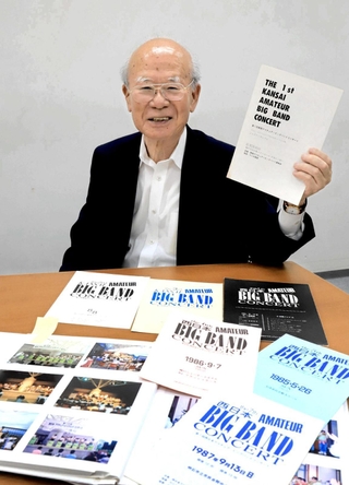 過去のコンサートのプログラムや写真を前に語る港良一さん＝神戸市中央区東川崎町１、神戸新聞社