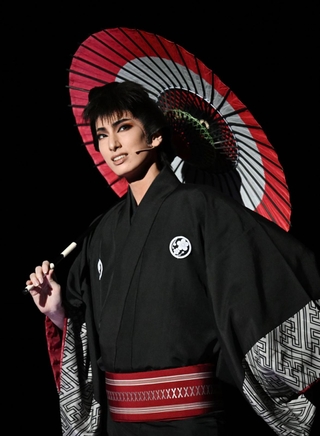 傘を片手に１人歩く礼三郎（柚香光）＝宝塚大劇場（撮影・三津山朋彦）