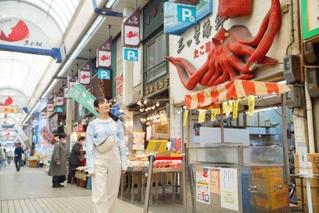 武田梨奈さん演じる主人公村崎ワカコが、明石で魚の棚商店街を散策する場面（（Ｃ）新久千映／コアミックス（Ｃ）２０２３「ワカコ酒７」製作委員会）