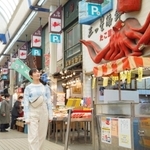 武田梨奈さん演じる主人公村崎ワカコが、明石で魚の棚商店街を散策する場面（（Ｃ）新久千映／コアミックス（Ｃ）２０２３「ワカコ酒７」製作委員会）