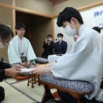 立会人の福崎文吾九段（左）に封じ手を渡す藤井聡太王位（右）。左から２人目は佐々木大地七段＝１３日午後、神戸市北区有馬町、中の坊瑞苑（撮影・小林良多）