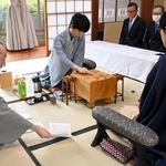 立会人の中田功八段（左）から封じ手を示される佐々木大地七段（右）。中央は着手する藤井聡太王位（中央）＝１６日午前、佐賀県嬉野市、和多屋別荘