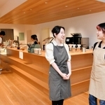 木がふんだんに使われたカウンターの前でカフェ運営について語る林楽騏さん（左）と西山夏海さん＝いずれも東京都新宿区