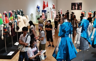 Ｐｅｒｆｕｍｅの歴代ステージ衣装がずらりと並ぶ中、多くの来館者でにぎわう展示室＝９日午前、神戸市中央区脇浜海岸通１（撮影・長嶺麻子）