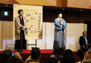 終局後、大盤解説会場であいさつする両対局者＝１２日夜、神戸市中央区（撮影・小林伸哉）