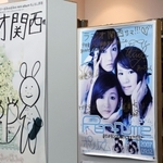 ２００７年発表のシングル「ポリリズム」の直筆サイン入りポスター（中央）。左は同じ中田ヤスタカ氏を音楽プロデューサーとするきゃりーぱみゅぱみゅのポスター＝神戸市中央区東川崎町１、ラジオ関西（撮影・長嶺麻子）
