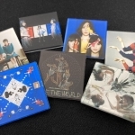 「ＣＯＳＭＩＣ　ＥＸＰＬＯＲＥＲ」「ワンルーム・ディスコ」などのＣＤジャケットのアクリルバッジ（記者私物）