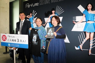 （左から）野村孝副館長からＴシャツと図録を贈られる松岡実優さん、来美さん＝神戸市中央区脇浜海岸通１