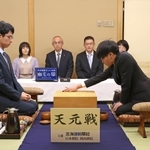 第一着を打つ関航太郎天元（右）と一力遼二冠＝１７日午前、札幌市、ホテルエミシア札幌