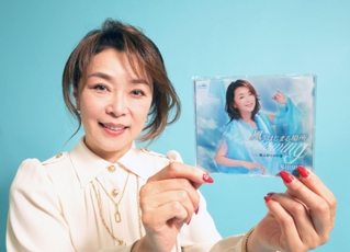 新しくリリースされたＣＤを手に笑顔を見せる歌手の多田周子さん＝神戸市中央区東川崎町１、神戸新聞社（撮影・風斗雅博）