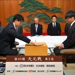 第一着を打つ一力遼二冠（左）と関航太郎天元＝２２日午前、福岡市中央区、大濠公園能楽堂