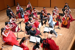 佐渡裕さん（中央右）の指揮の下、演奏を披露するスーパーストリングスコーベの奏者たち＝２７日夜、神戸市中央区東川崎町１、神戸新聞松方ホール（撮影・風斗雅博）
