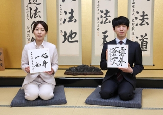 好きな言葉を書いた色紙を持つ藤井聡太王位（右）と里見加奈女流王位＝関西将棋会館