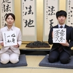 好きな言葉を書いた色紙を持つ藤井聡太王位（右）と里見加奈女流王位＝関西将棋会館