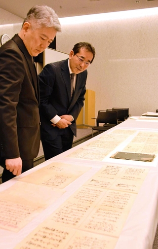 羽柴秀吉関連の史料を眺める村井祐樹・東京大史料編纂所准教授（左）と兵庫県立歴史博物館の前田徹学芸員＝姫路市本町