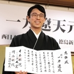 允許状を手に笑顔を見せる一力遼天元＝２２日午後、東京都千代田区、日本プレスセンタービル