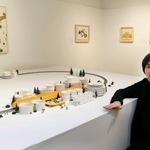 ミニチュア作家の田中達也と代表作「新パン線」。パンが走る仕掛けが施されたのは本展だけ＝神戸市中央区小野柄通８、神戸阪急