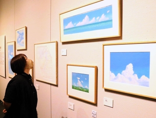 山本二三さんの代名詞でもある雲の描写が堪能できる展示＝神戸ファッション美術館