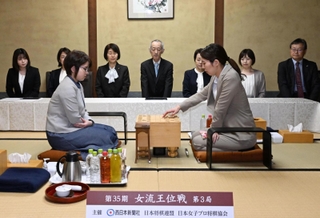 女流王位戦第３局で初手を指す福間香奈女流王位（右）。左は加藤桃子女流四段＝２３日午前、福岡県飯塚市、麻生大浦荘