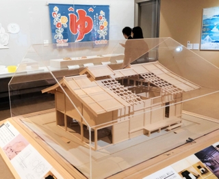 湯屋を復元した模型や銭湯ののれんなどが並ぶ会場＝神戸市立博物館