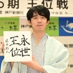 王位５連覇を果たし、永世王位の資格を得た藤井聡太王位。会見では色紙を手に笑顔を見せた＝２８日午後、神戸市北区有馬町、中の坊瑞苑（撮影・大田将之）