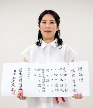 就位状を手にする福間香奈女流王位＝大阪市福島区、関西将棋会館（撮影・小林伸哉）