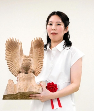 記念品の木彫り作品を手にする福間香奈女流王位＝大阪市福島区、関西将棋会館（撮影・小林伸哉）