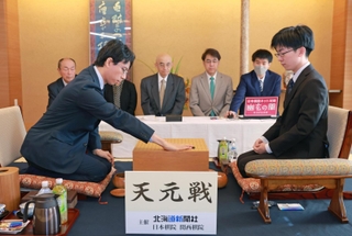 第一着を打つ一力遼天元（左）と芝野虎丸名人＝18日午前、札幌市中央区、京王プラザホテル札幌