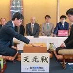 第一着を打つ一力遼天元（左）と芝野虎丸名人＝18日午前、札幌市中央区、京王プラザホテル札幌