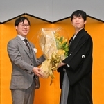 囲碁の井山裕太三冠（左）から花束を受け取った藤井聡太王位＝１２日午後、東京都千代田区