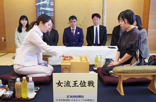 第２局で初手を指す福間香奈女流王位。右は伊藤沙恵女流四段＝１３日午前、札幌市中央区、京王プラザホテル札幌