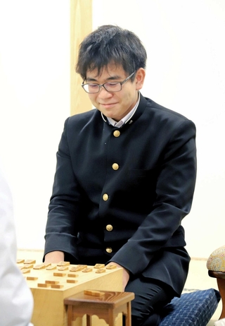 プロ初勝利を挙げた対局を終えて、笑顔を見せる炭崎俊毅四段＝１１日、大阪府高槻市、関西将棋会館
