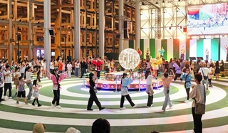 会期中、毎晩開催される「盆踊りのアシタ」。国籍や老若男女問わず、多くの人がカラオケ歌唱に合わせて輪になって踊る＝大阪市此花区の夢洲